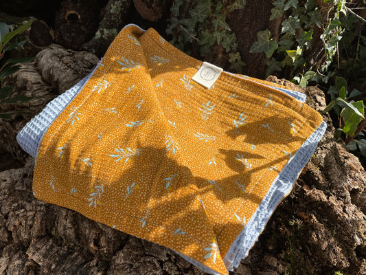 Plaid azul y mostaza plegado, textil hogar algodón orgánico 127x140cm