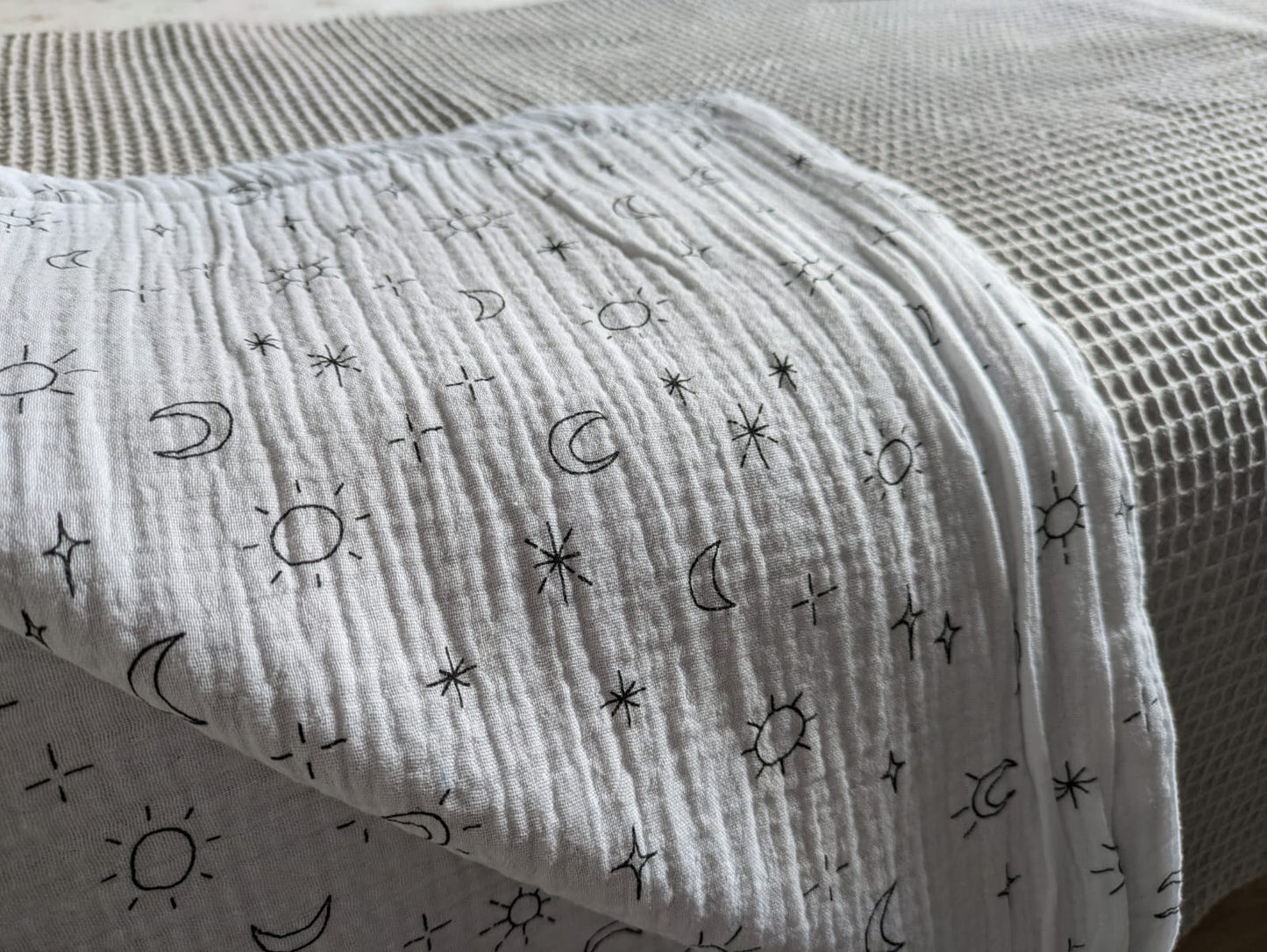 Plaid Sami gris y blanca  con estampados de sol, estrellas y lunas. - Doble capa Muselina y Wafle